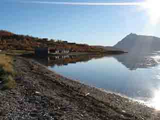 Bright day with mirrored boathouses (Sand, Norway)