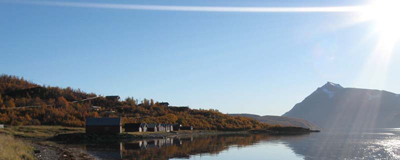 Bright day with mirrored boathouses (Sand, Norway)