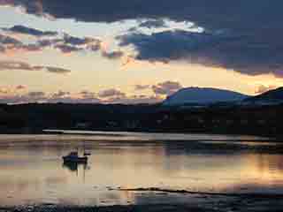 Boat in striated sunset reflections (From near Mestervik, Norway)